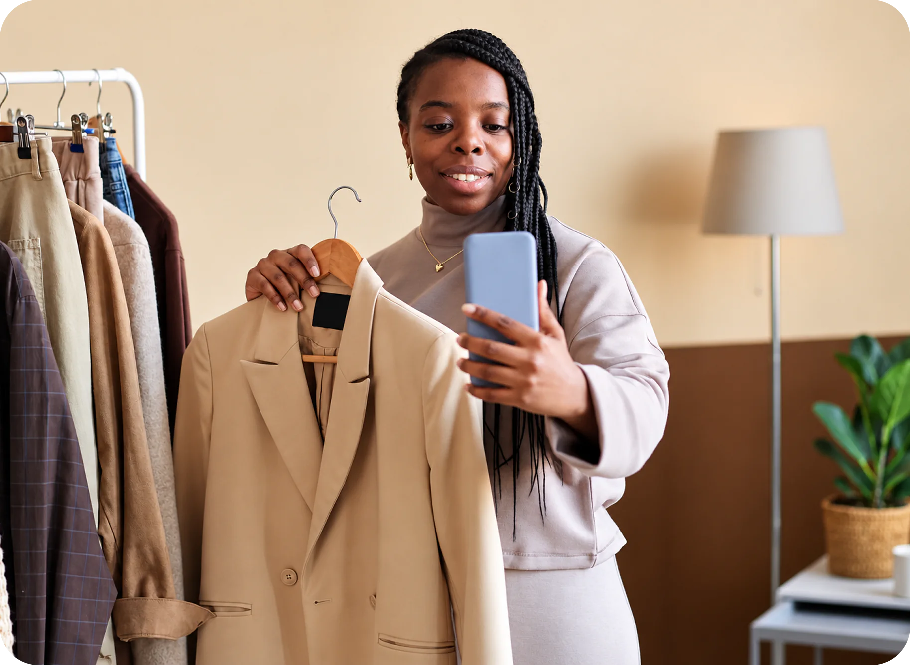A shop owner showing a jacket while managing her store on her phone